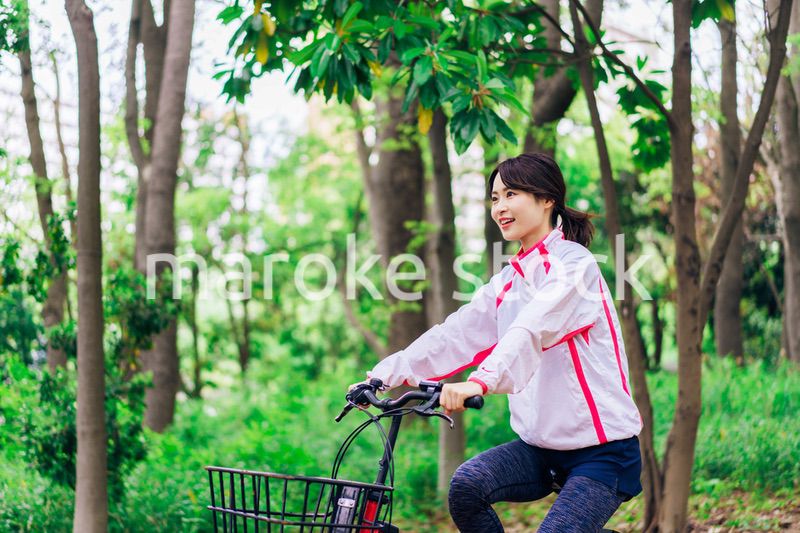 自然の中でサイクリングを楽しむ若い女性