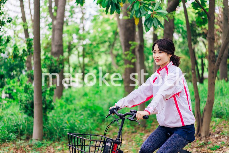 自然の中でサイクリングを楽しむ若い女性