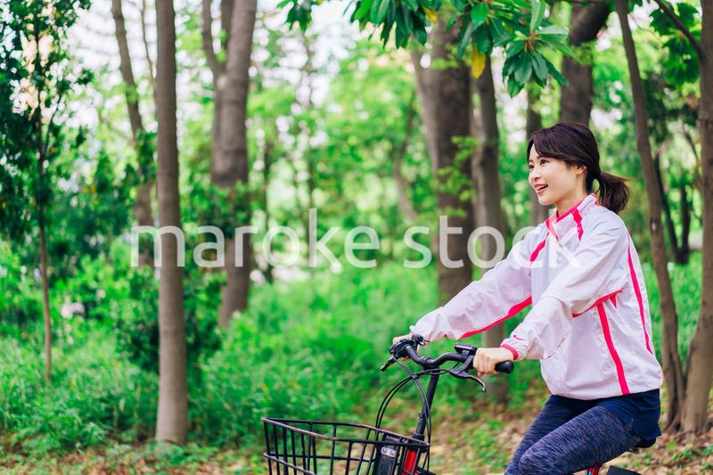 自然の中でサイクリングを楽しむ若い女性