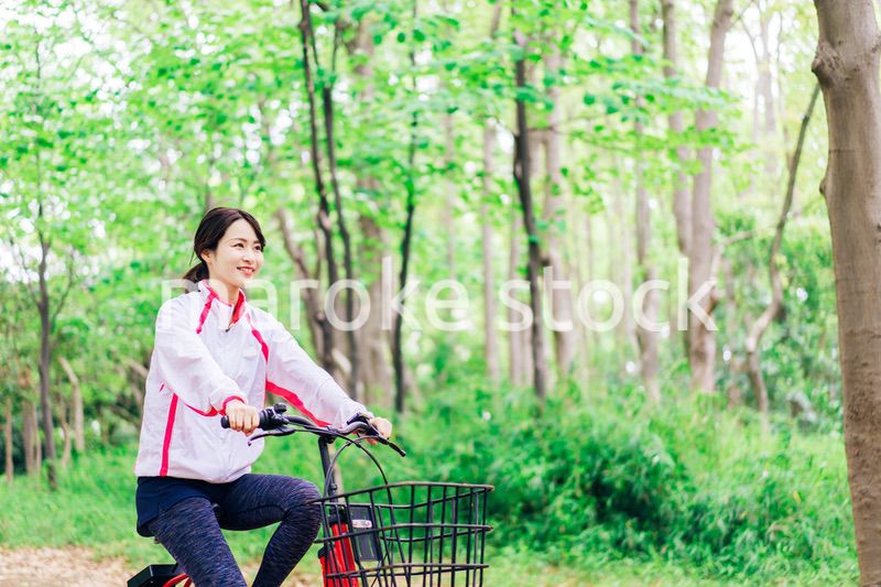 自然の中でサイクリングを楽しむ若い女性