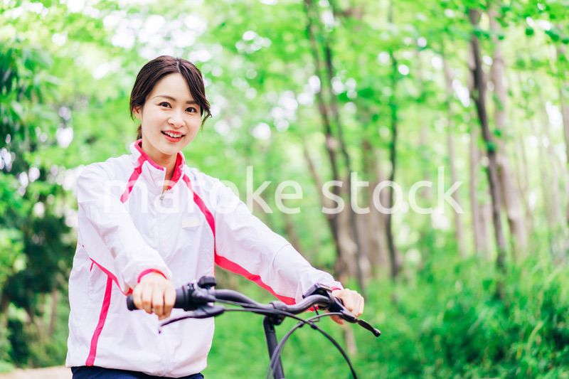 自然の中でサイクリングを楽しむ若い女性