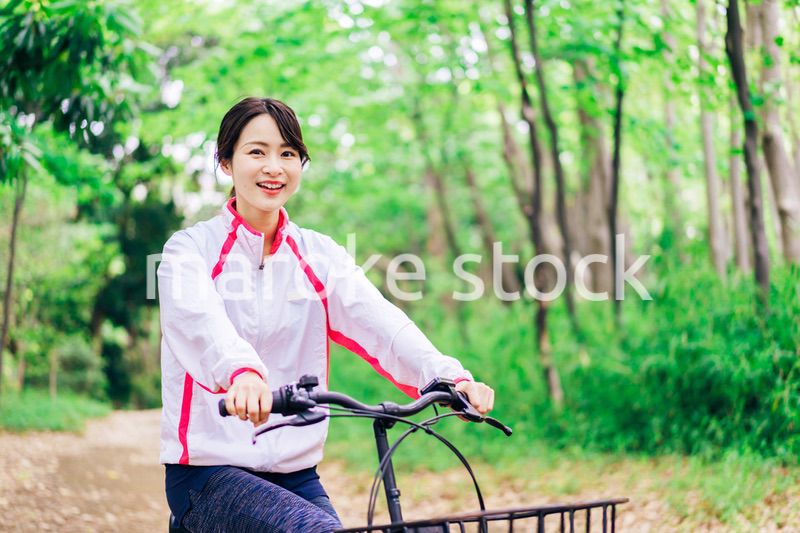 自然の中でサイクリングを楽しむ若い女性