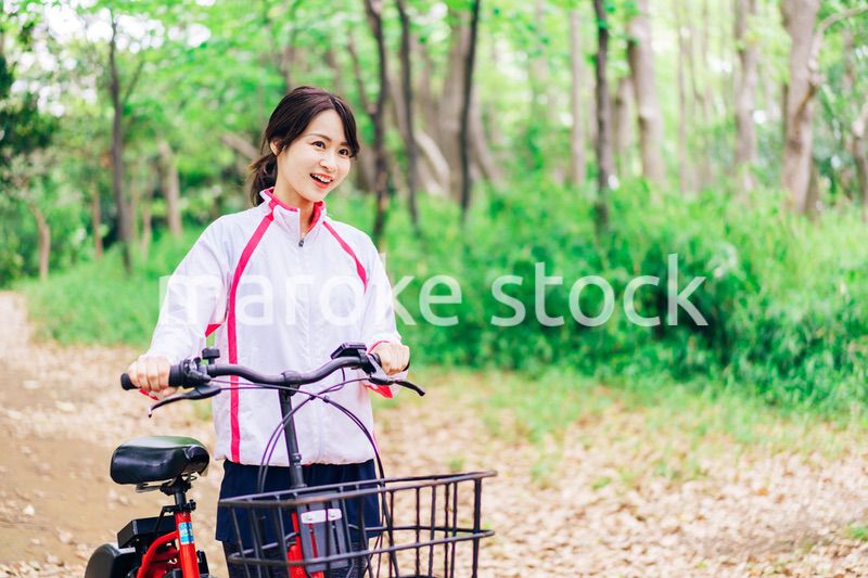 自然の中でサイクリングを楽しむ若い女性