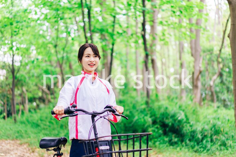 自然の中でサイクリングを楽しむ若い女性