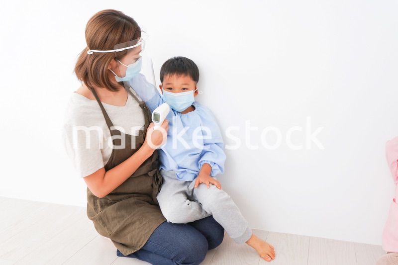 園児の検温をする保育士