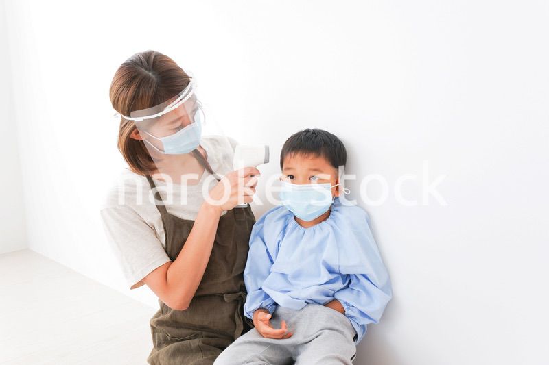 園児の検温をする保育士