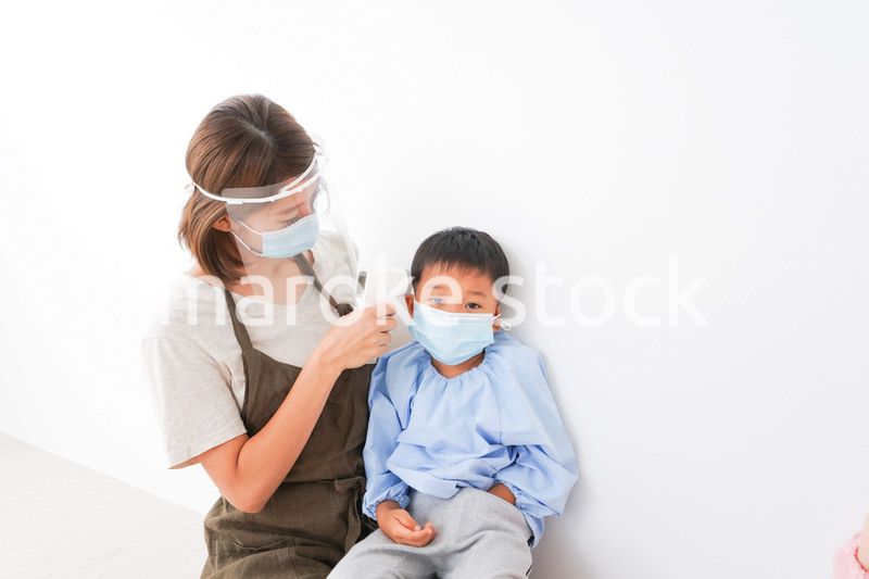 園児の検温をする保育士