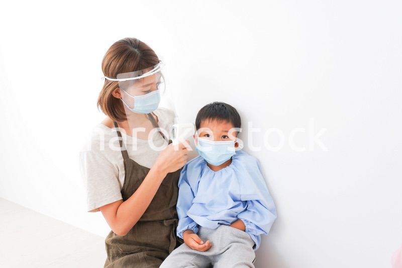 園児の検温をする保育士