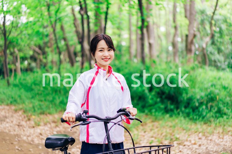 自然の中でサイクリングを楽しむ若い女性