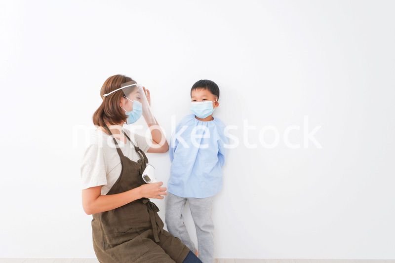 園児の検温をする保育士