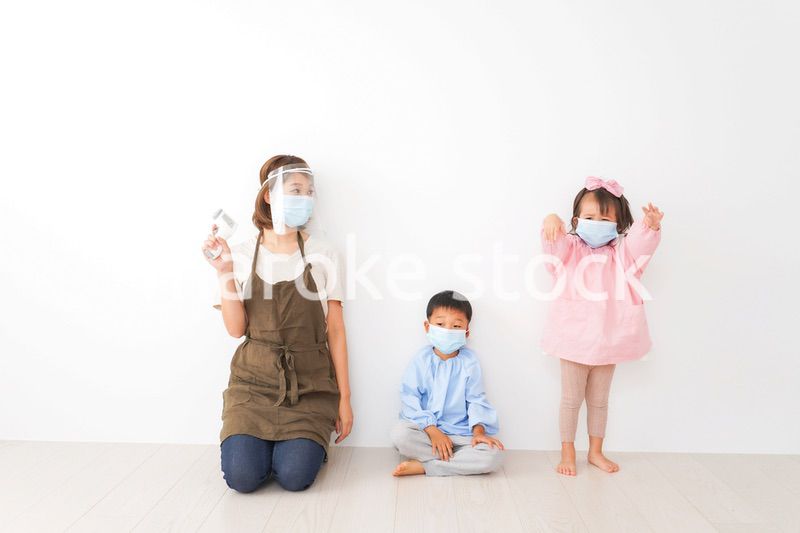 体温測定をする先生と幼稚園児