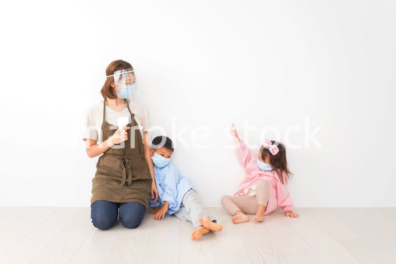 体温測定をする先生と幼稚園児