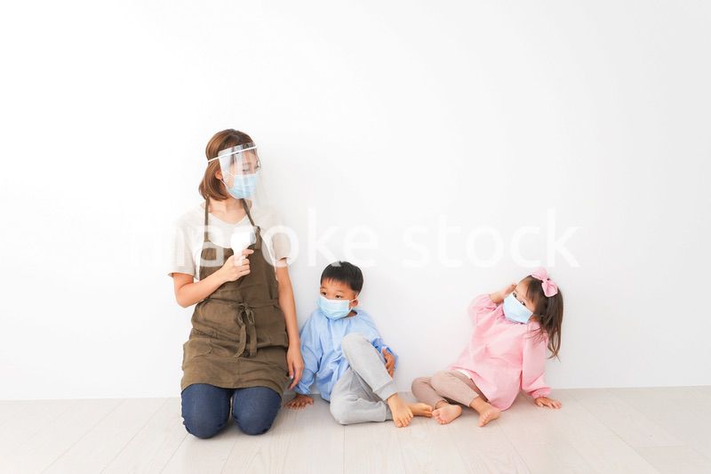 体温測定をする先生と幼稚園児