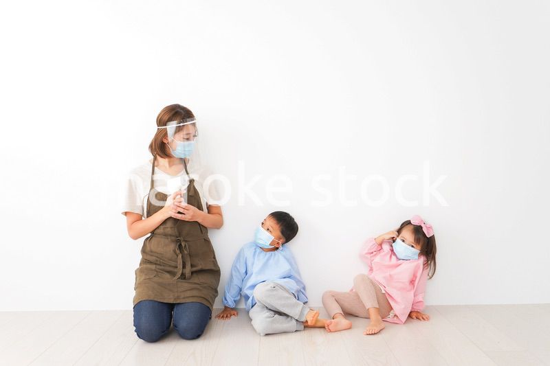 体温測定をする先生と幼稚園児