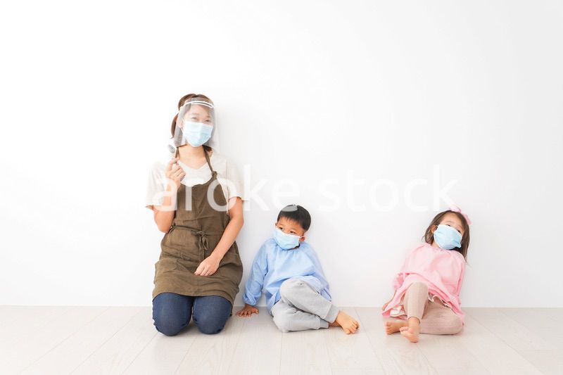 体温測定をする先生と幼稚園児