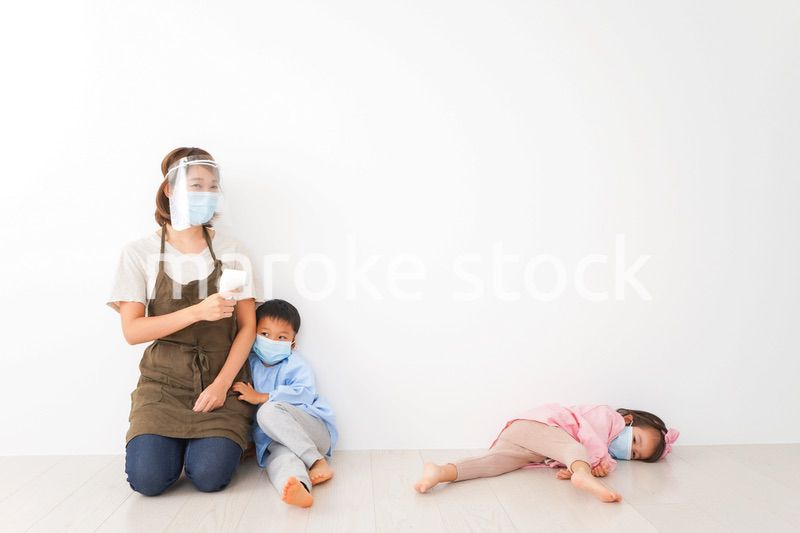 体温測定をする先生と幼稚園児