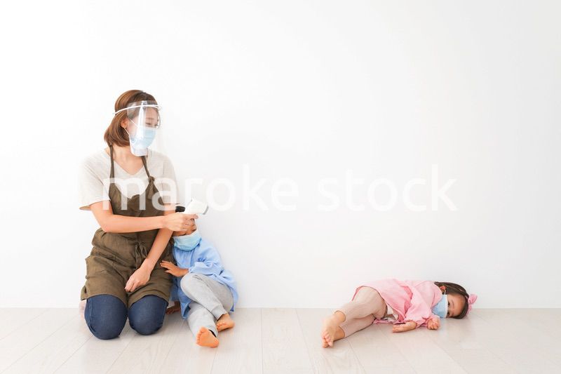 体温測定をする先生と幼稚園児