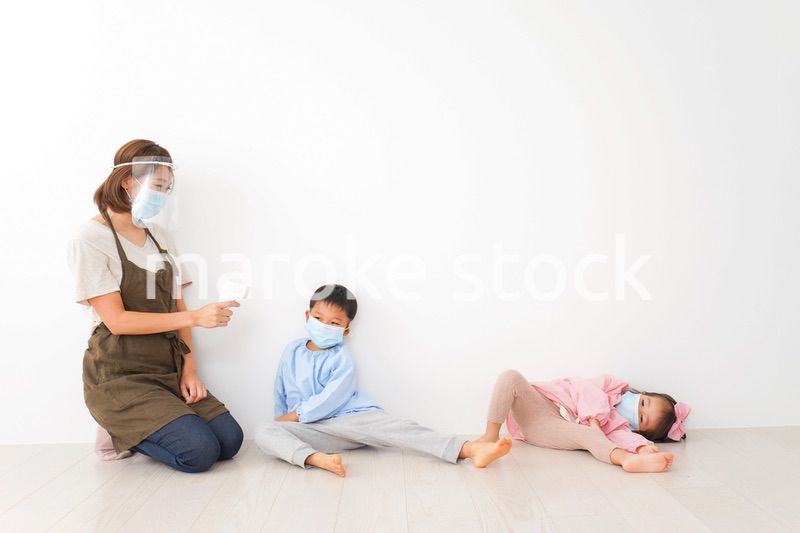 体温測定をする先生と幼稚園児