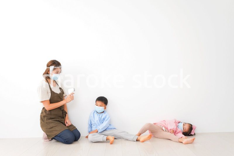 体温測定をする先生と幼稚園児