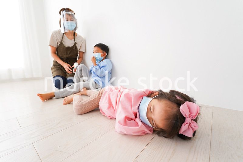 体温測定をする先生と幼稚園児