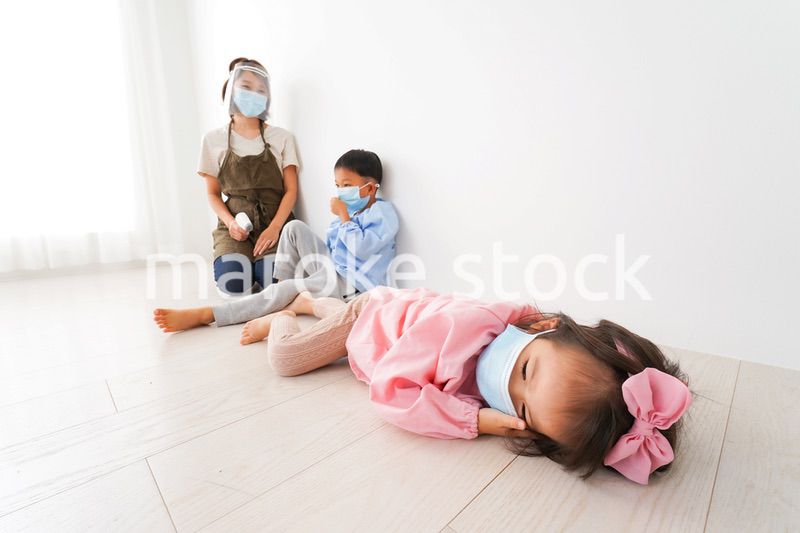 体温測定をする先生と幼稚園児