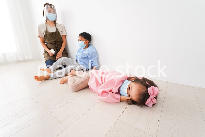 体温測定をする先生と幼稚園児