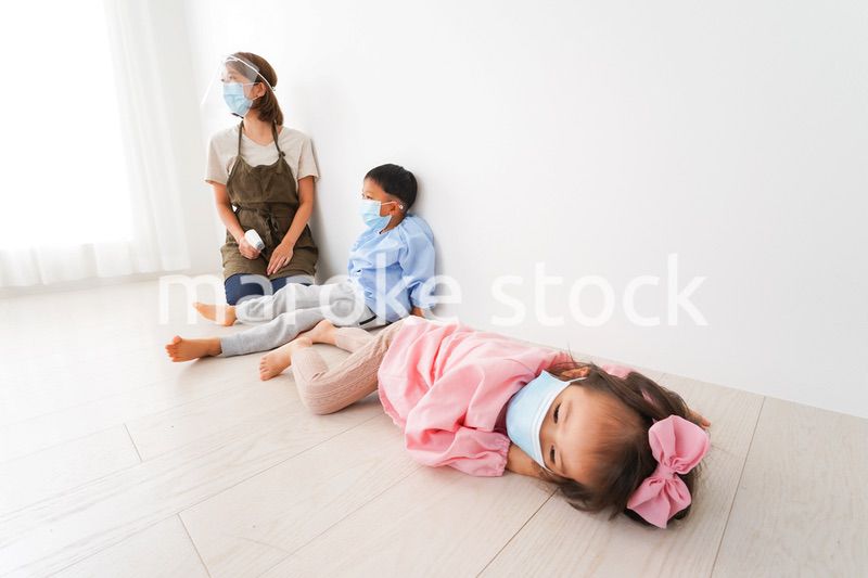 体温測定をする先生と幼稚園児