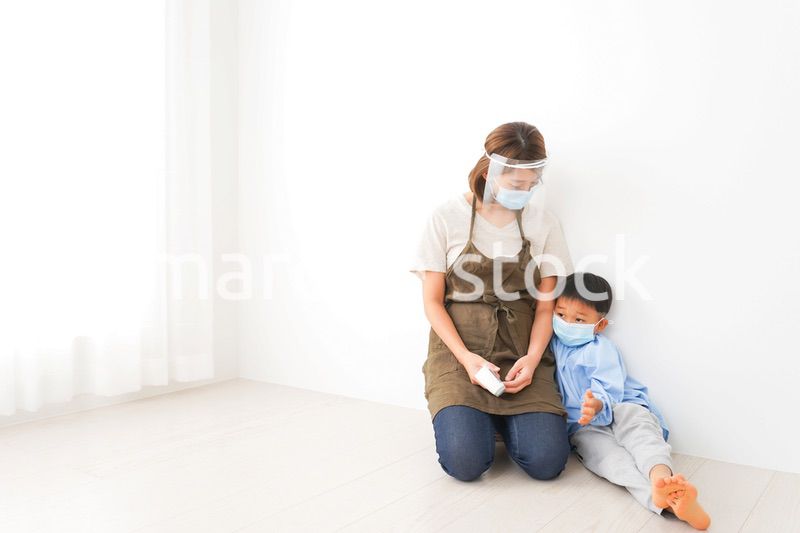 幼児の体温測定をする保育士