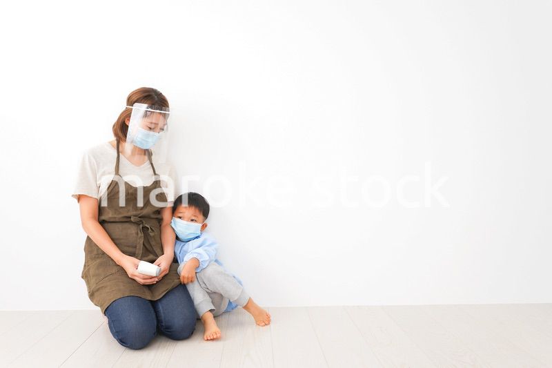 幼児の体温測定をする保育士