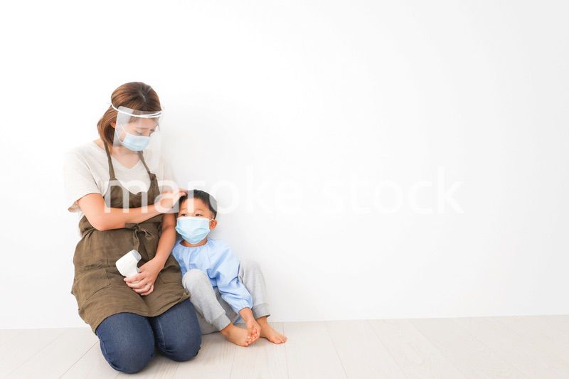 幼児の体温測定をする保育士