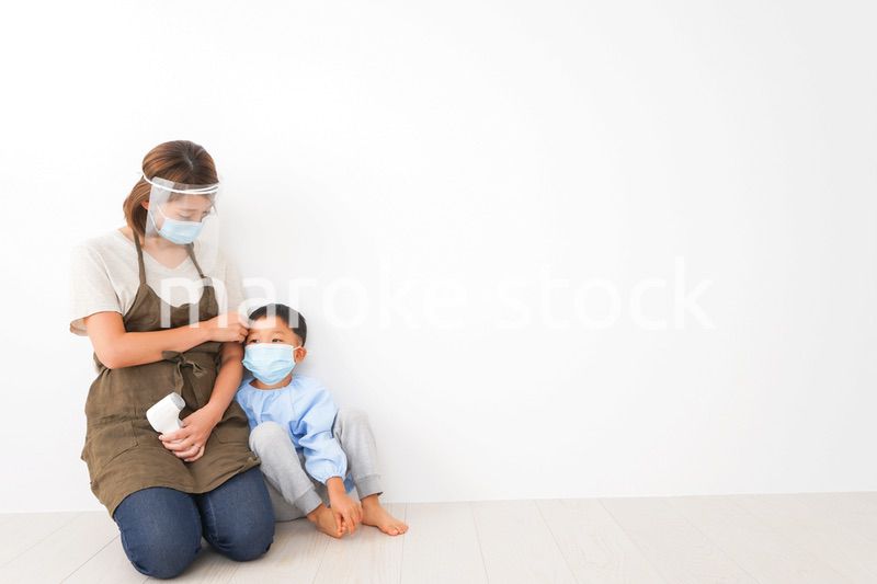 幼児の体温測定をする保育士