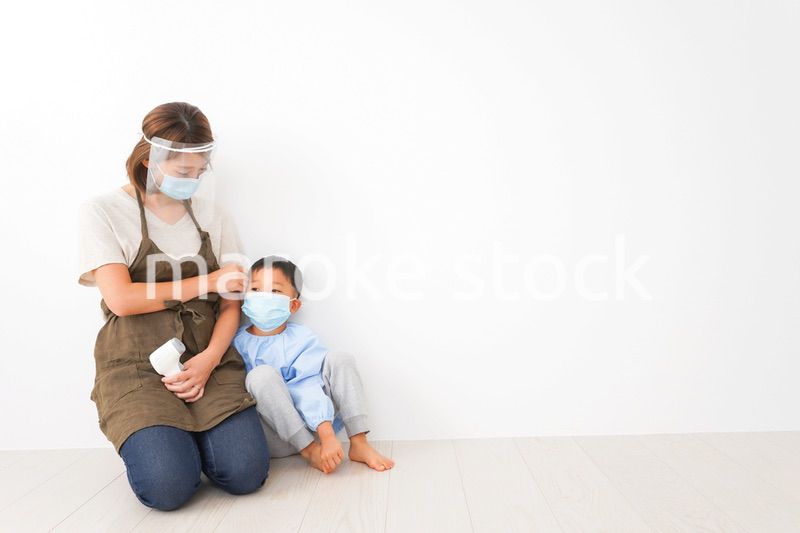 幼児の体温測定をする保育士