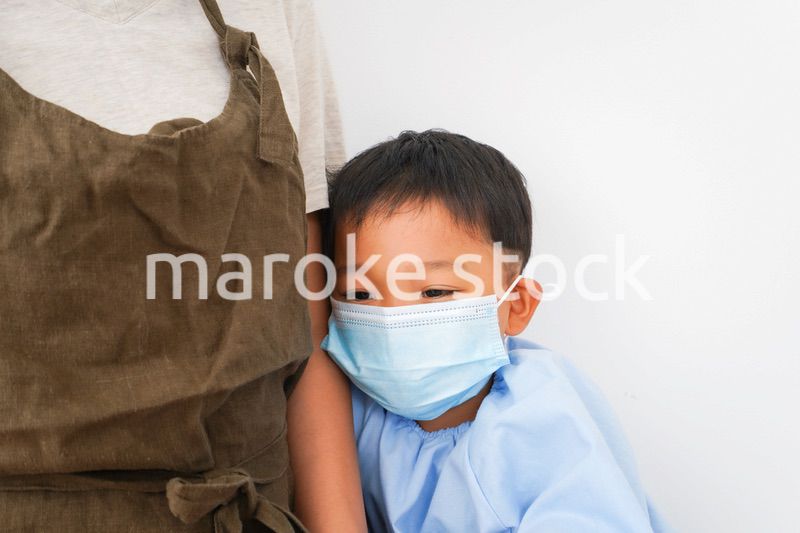 幼児の体温測定をする保育士