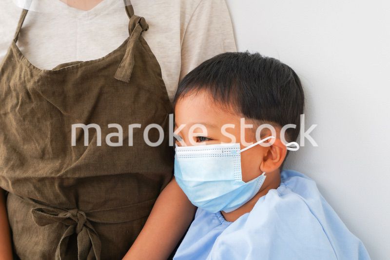 幼児の体温測定をする保育士