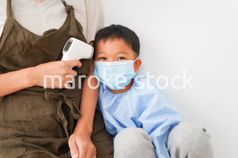 幼児の体温測定をする保育士