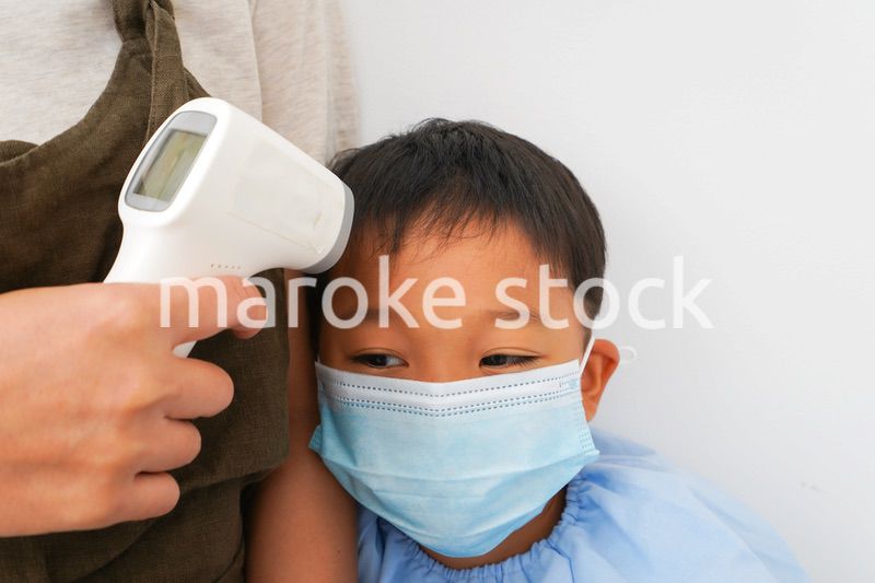 幼児の体温測定をする保育士