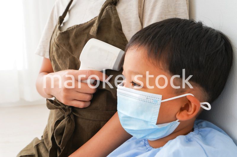 幼児の体温測定をする保育士