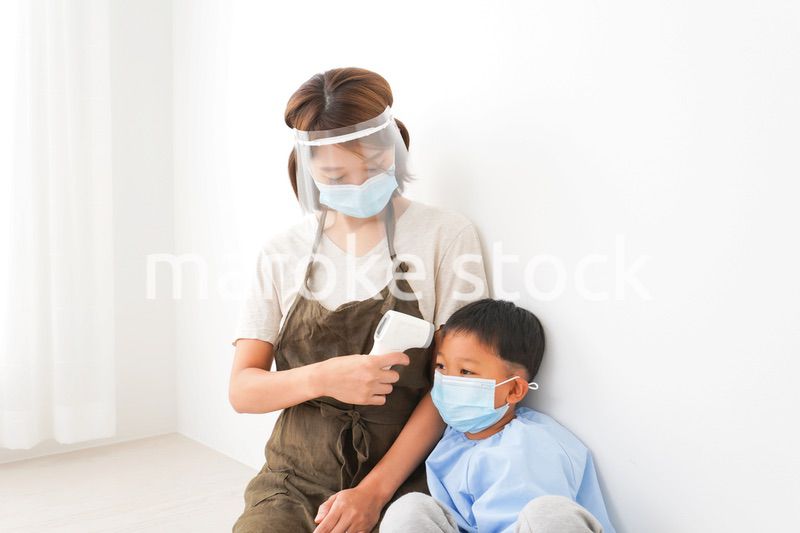 幼児の体温測定をする保育士