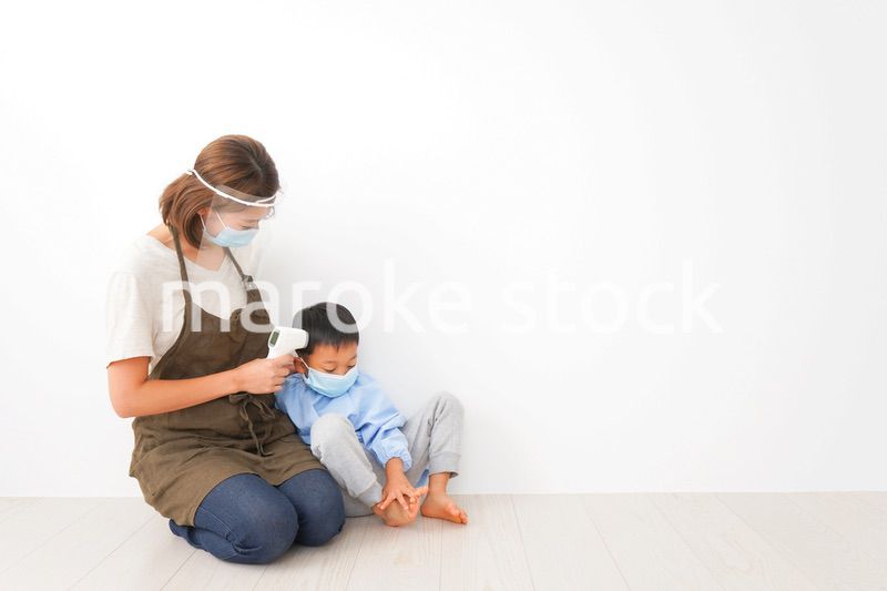 幼児の体温測定をする保育士