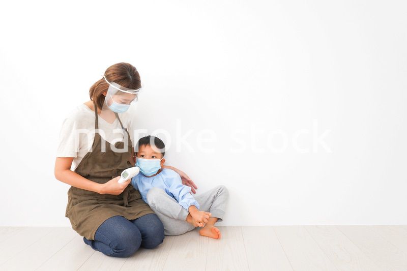 幼児の体温測定をする保育士