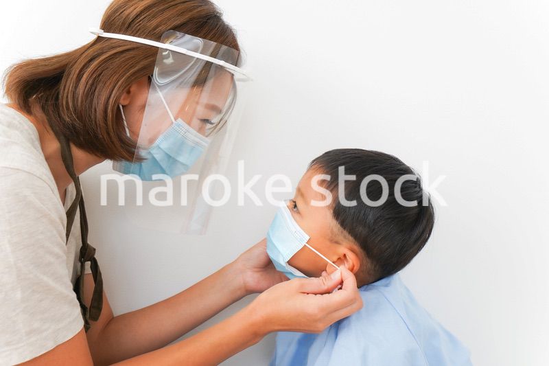 園児にマスクをつける保育士