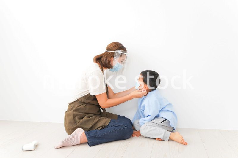 園児にマスクをつける保育士