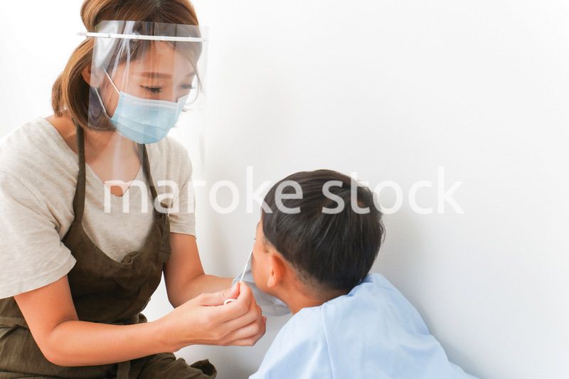 園児にマスクをつける保育士