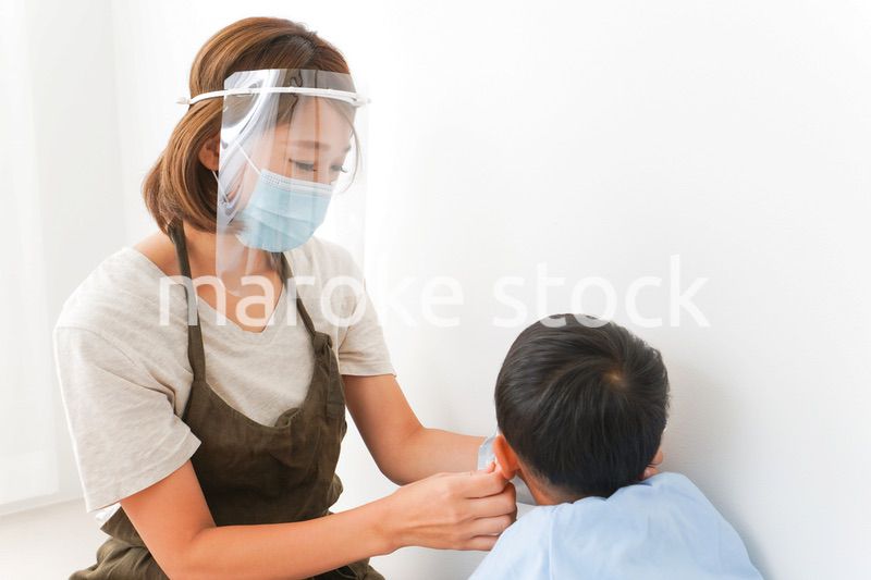 園児にマスクをつける保育士