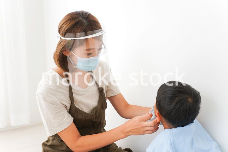 園児にマスクをつける保育士