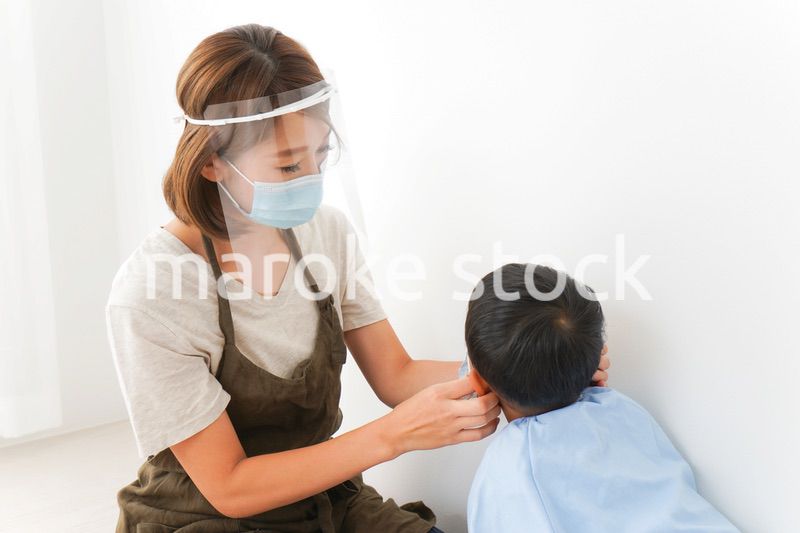 園児にマスクをつける保育士