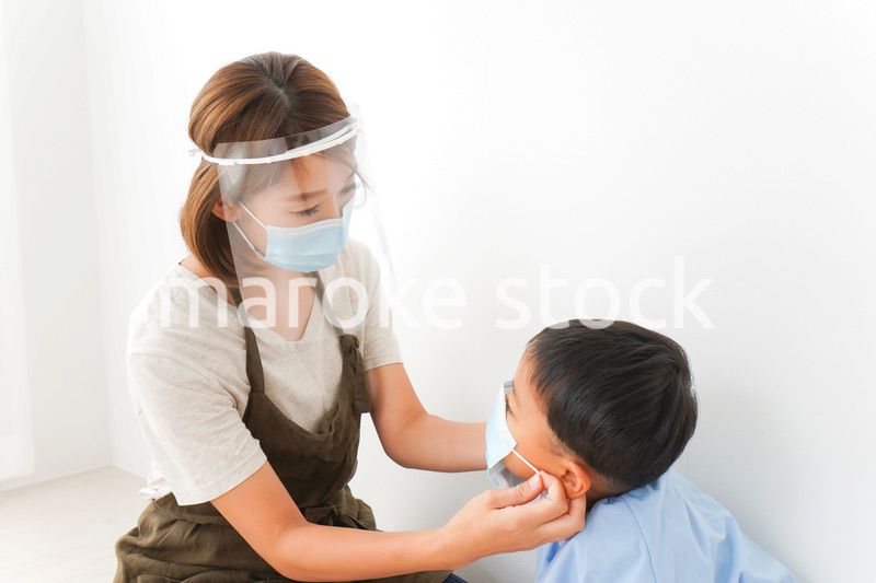 園児にマスクをつける保育士