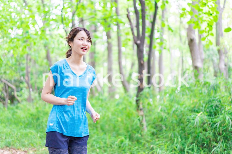 自然の中でランニングをする若い女性