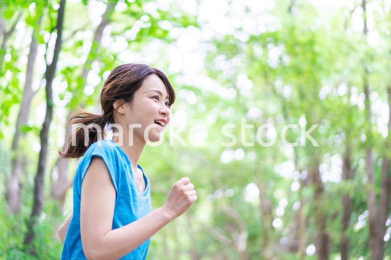 自然の中でランニングをする若い女性
