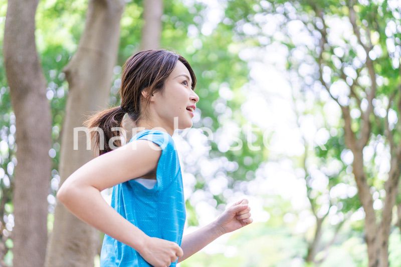 自然の中でランニングをする若い女性